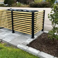 Snyggt insynsskydd för att bygga in soptunnor. Trälameller och svarta stolpar ger ett modernt utseende.