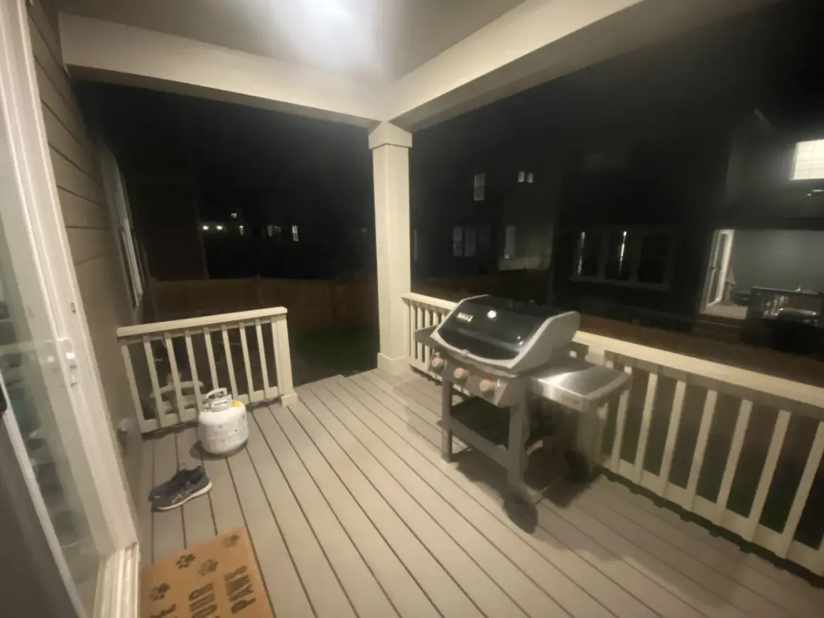 En gasolgrill under taket på altanen, redo för sommarens grillkvällar.