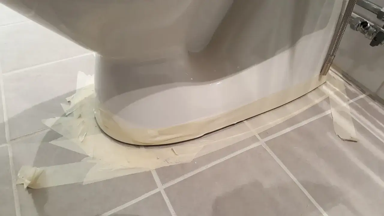 Maskeringstejp runt basen av en toalettstol, redo f&ouml;r fogning.