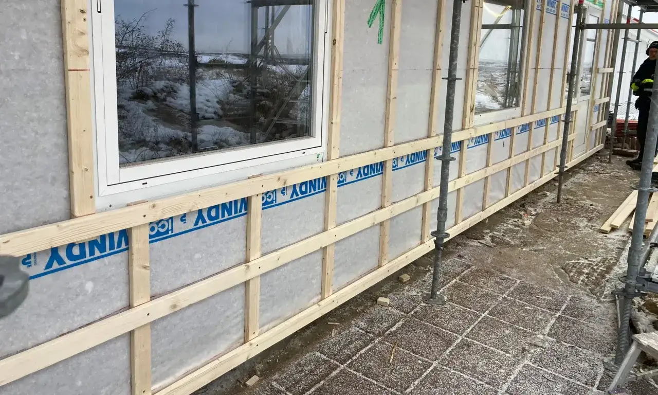 Byggnation av fasad med vindskydd och en ram för gammaldags lockpanel.